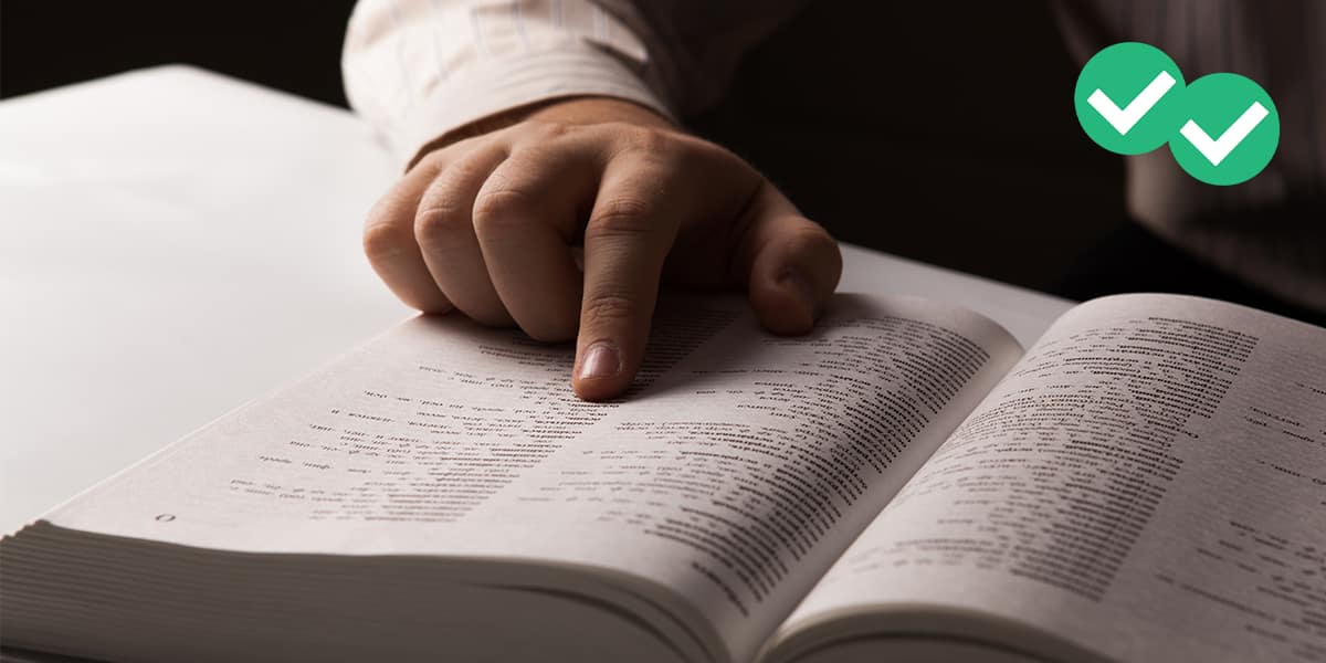 Close up of a man's finger as it skims through a dictionary