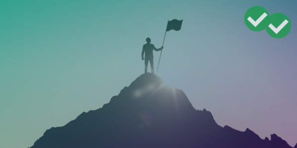 person holding a flag on the top of a hill representing gmat algebra domination -image by magoosh