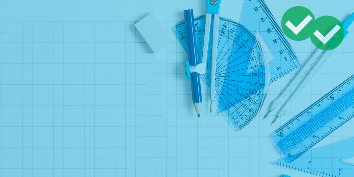 gmat geometry tools placed on top of graph paper, including protractor, compass with lead pencil attached, two triange rulers, standard ruler, and eraser -image by magoosh