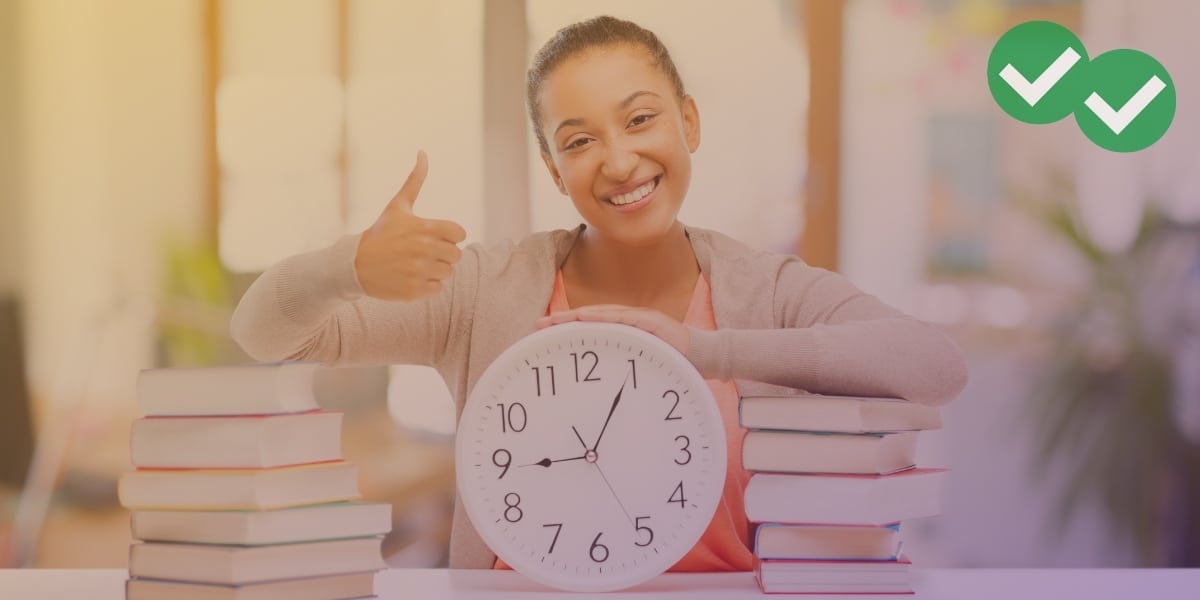 Student holding thumbs up over clock and books