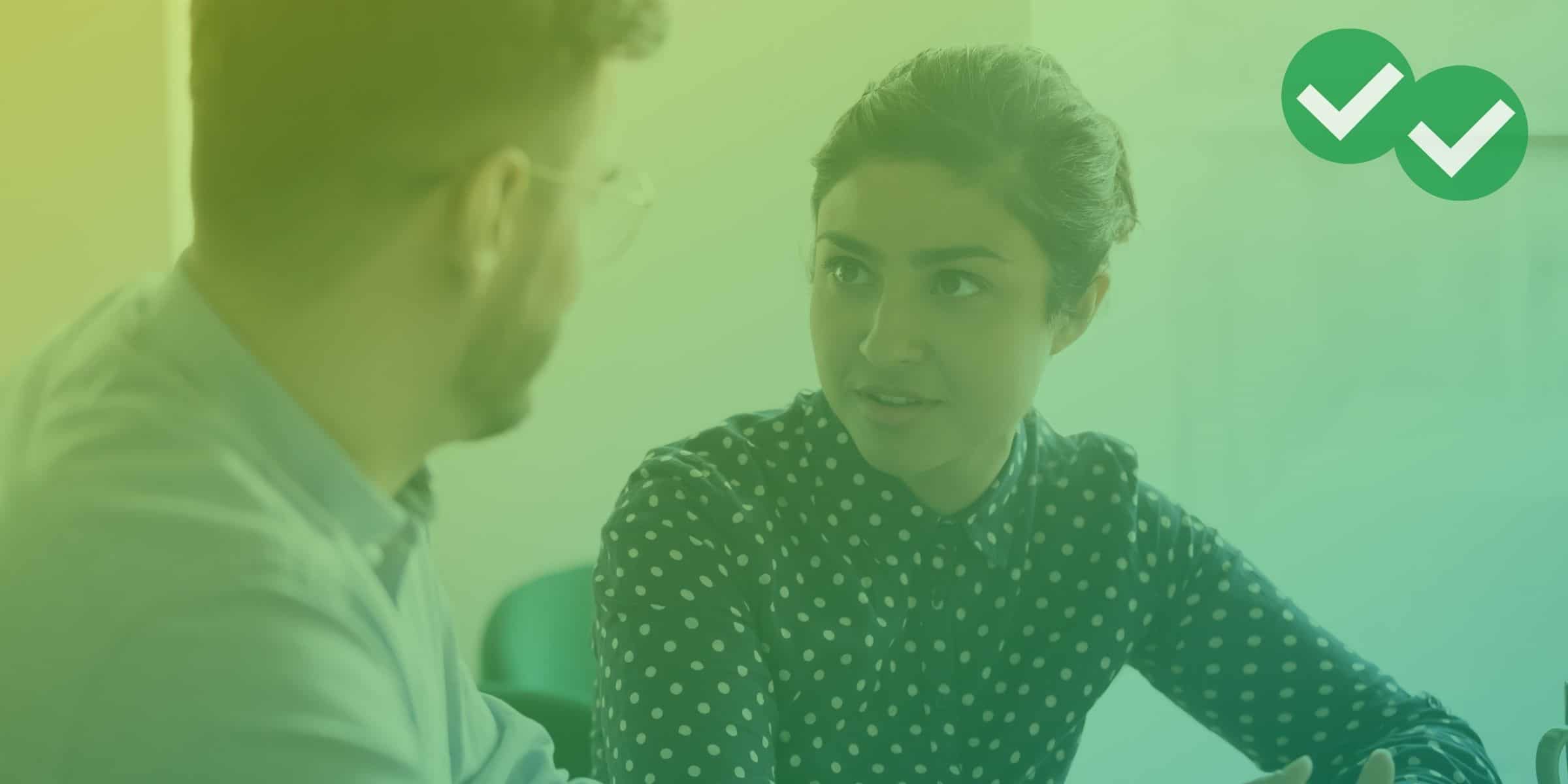 a woman speaking intently with a man at a table -magoosh