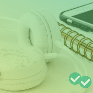 Headphones next to notebook and phone