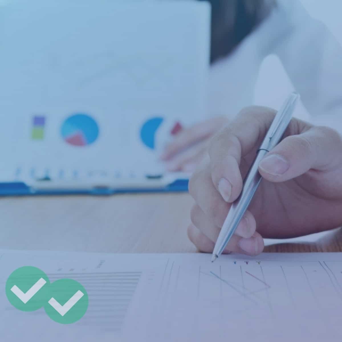 Person holding paper with multiple IELTS graphics while another person marks a separate sheet of graphs - image by Magoosh