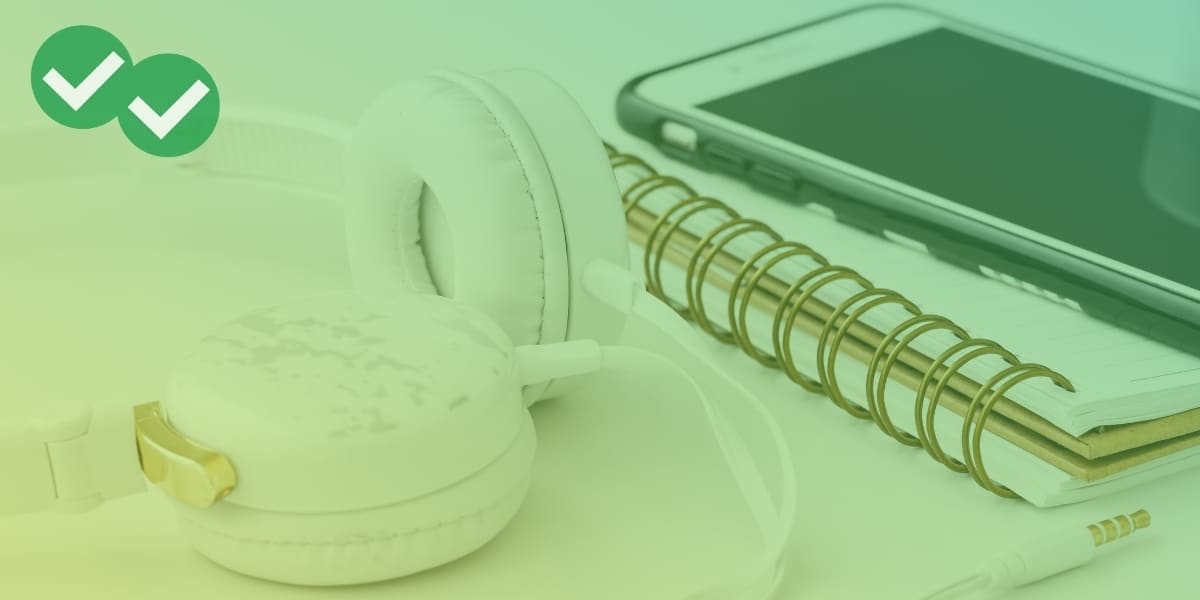 Headphones next to notebook and phone