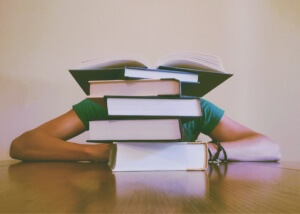 stack of books in front of a student - how hard is the lsat?