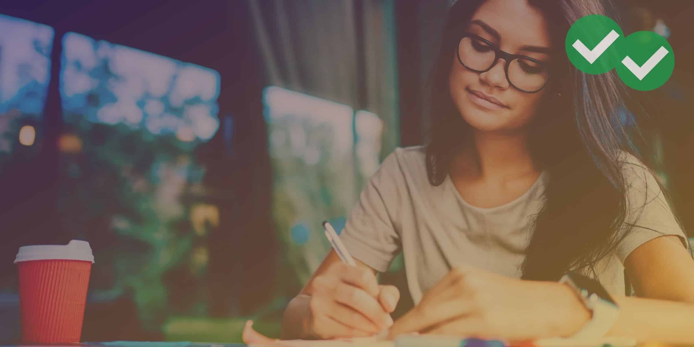 a student in glasses drafting her sat essay at her desk -magoosh