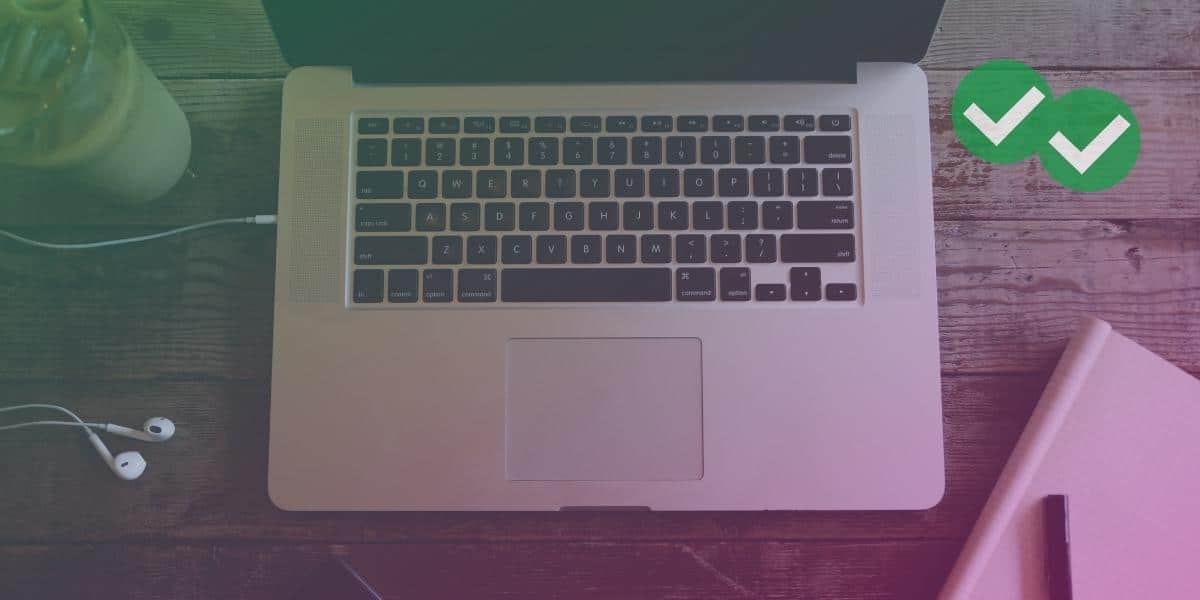 A laptop and a notebook with pen on a desk